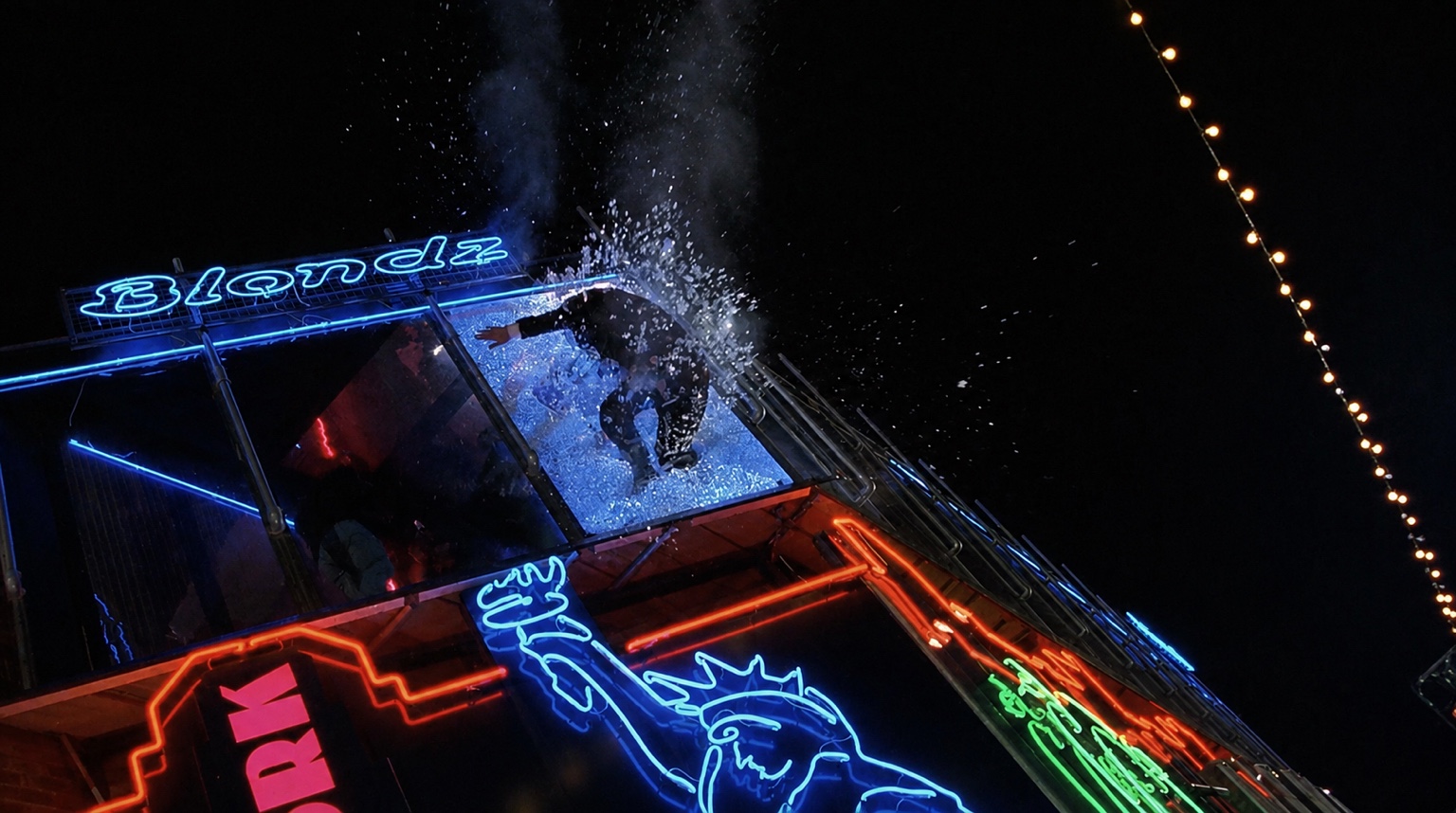 A stunt performer crashing through a high window in a shower of glass