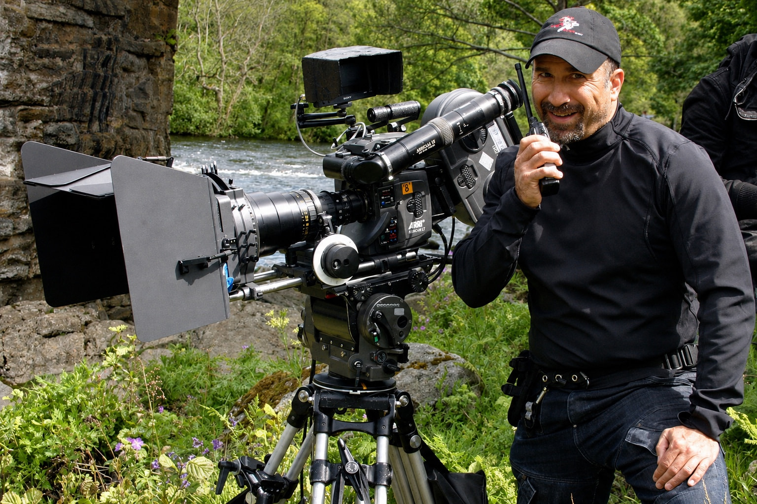 Peter beside a camera on a riverside location