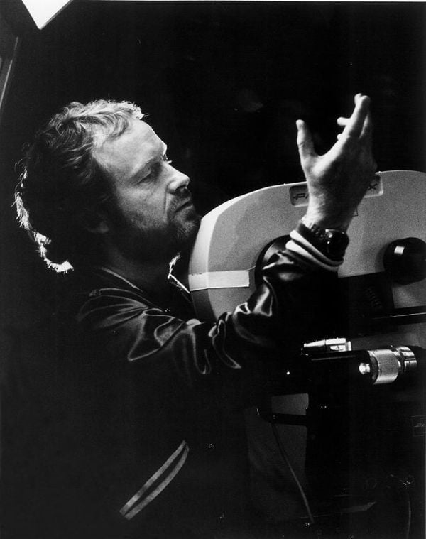 Ridley Scott gesturing beside a film camera